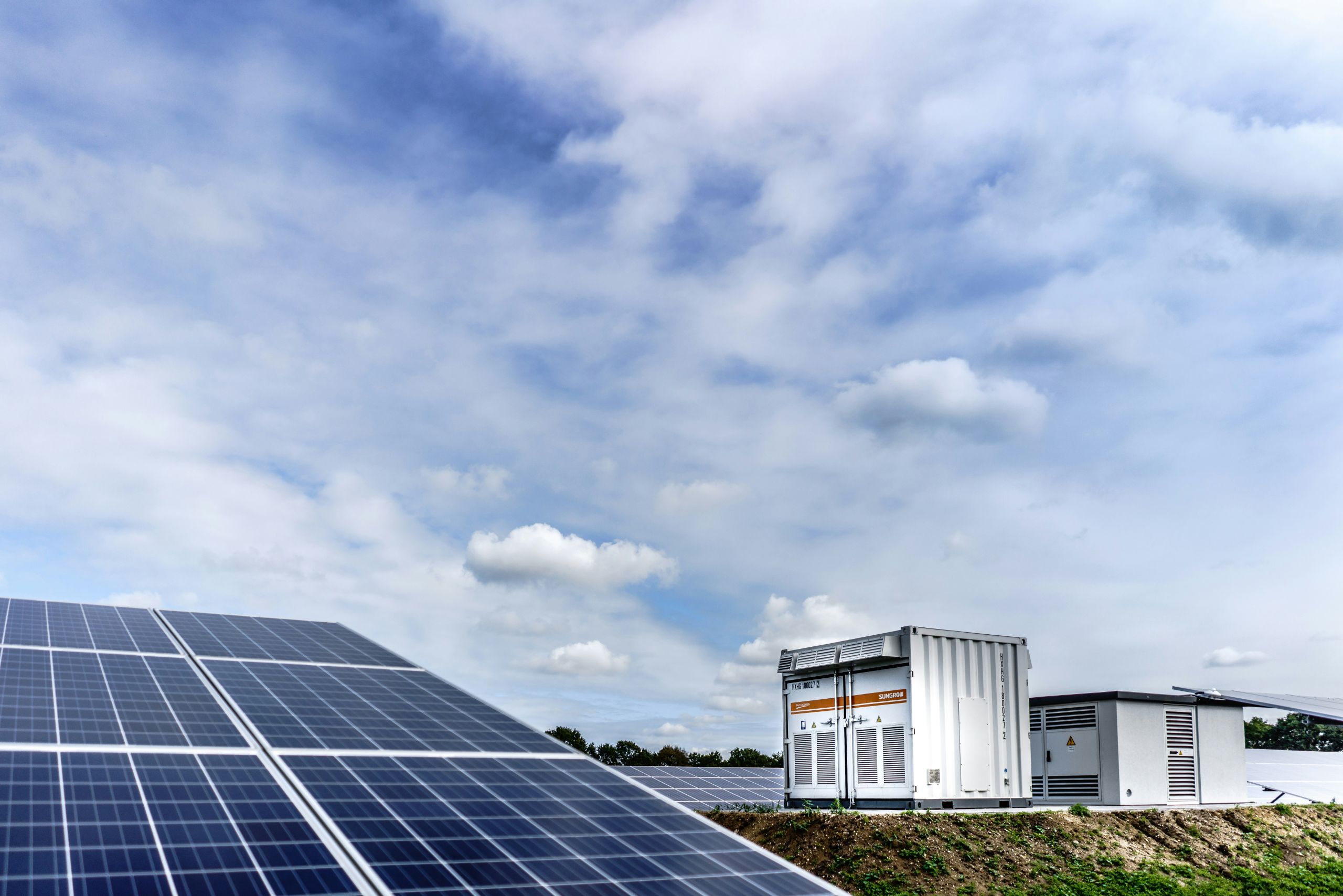 Solar panel in the foreground with batteries in the background