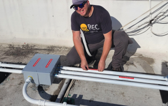 NEI installer completing junction point wiring, commercial solar project, Brea, California — National Energy Installers