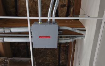 Hidden solar junction box routed beneath ceiling, commercial solar installation — National Energy Installers